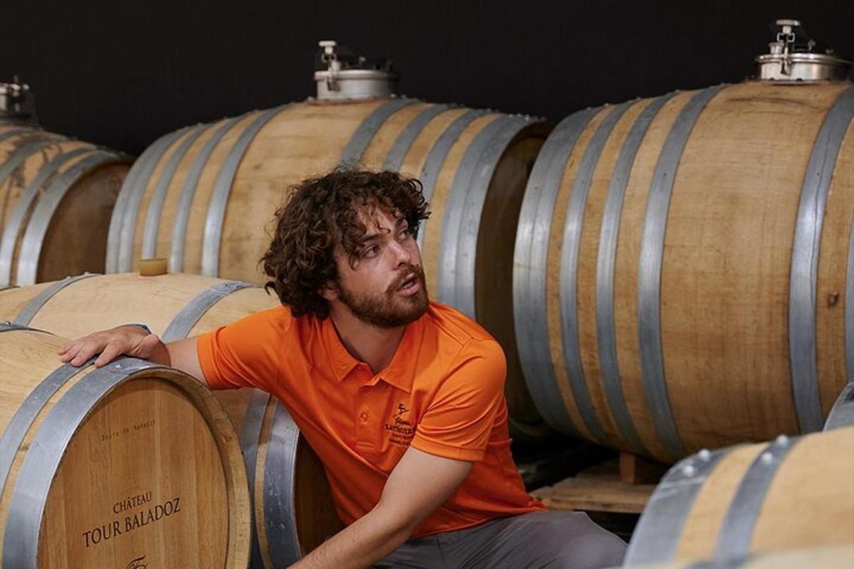 a man sitting in the middle of a bunch of wine barrels