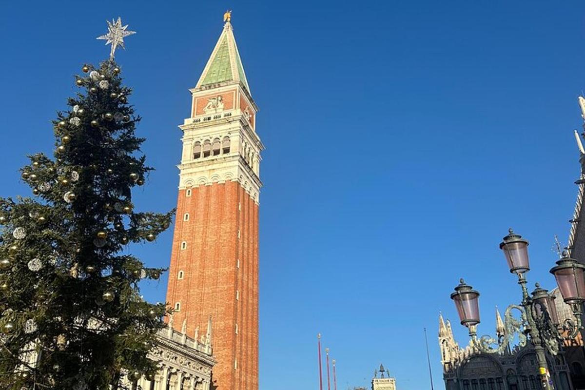 una torre dell'orologio con un albero di Natale di fronte a un edificio