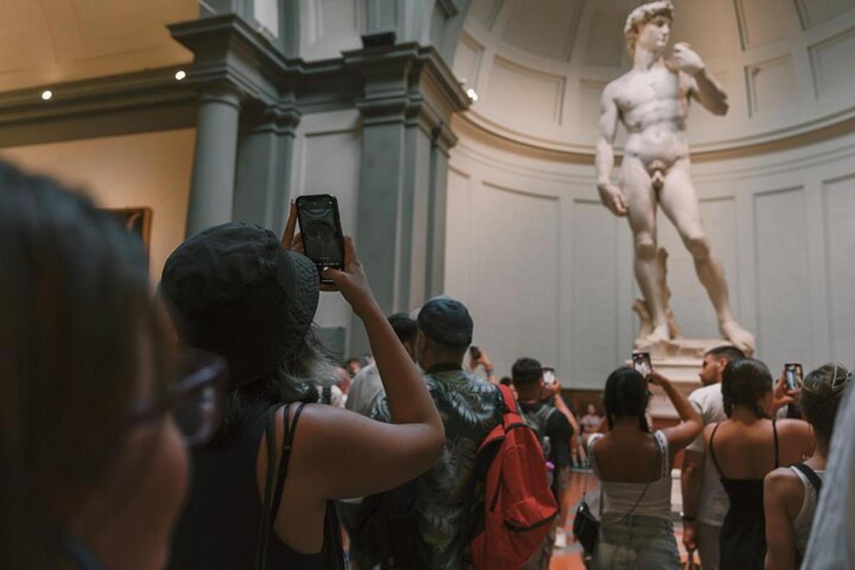 eine Frau, die ein Foto von einer Statue in einem Museum macht