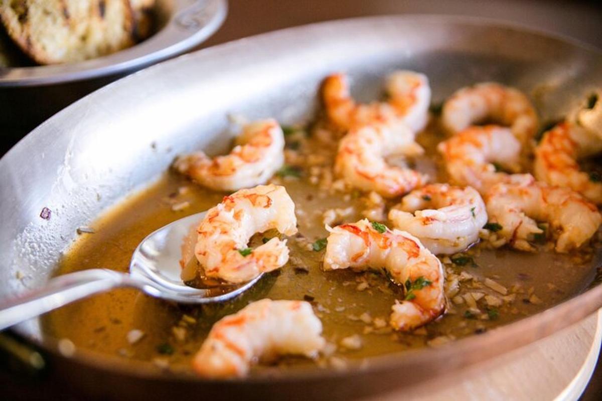 una cuchara en una sartén con camarones en salsa
