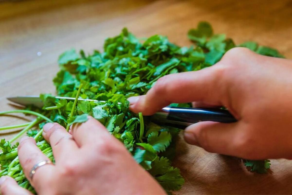 seseorang memotong sayur-sayuran di atas papan pemotong
