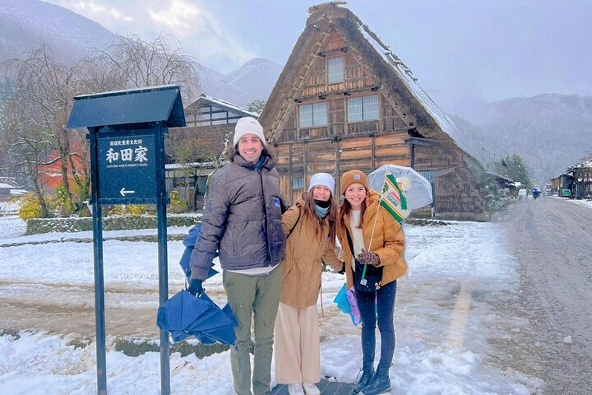 three people standing at a bus stop in front of a cabin