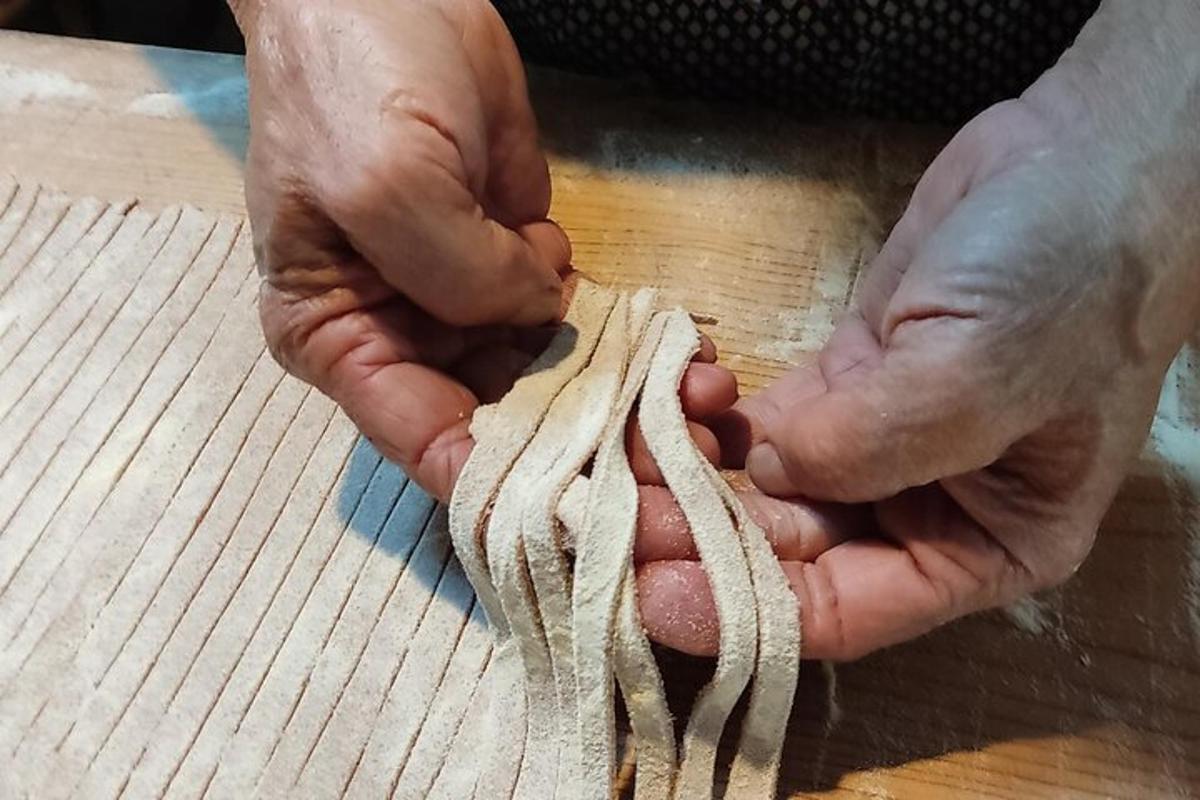 a pair of hands holding a piece of dough