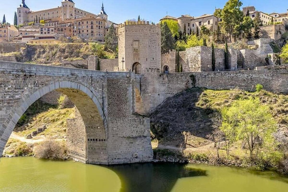 un vecchio ponte sopra un fiume con edifici sullo sfondo