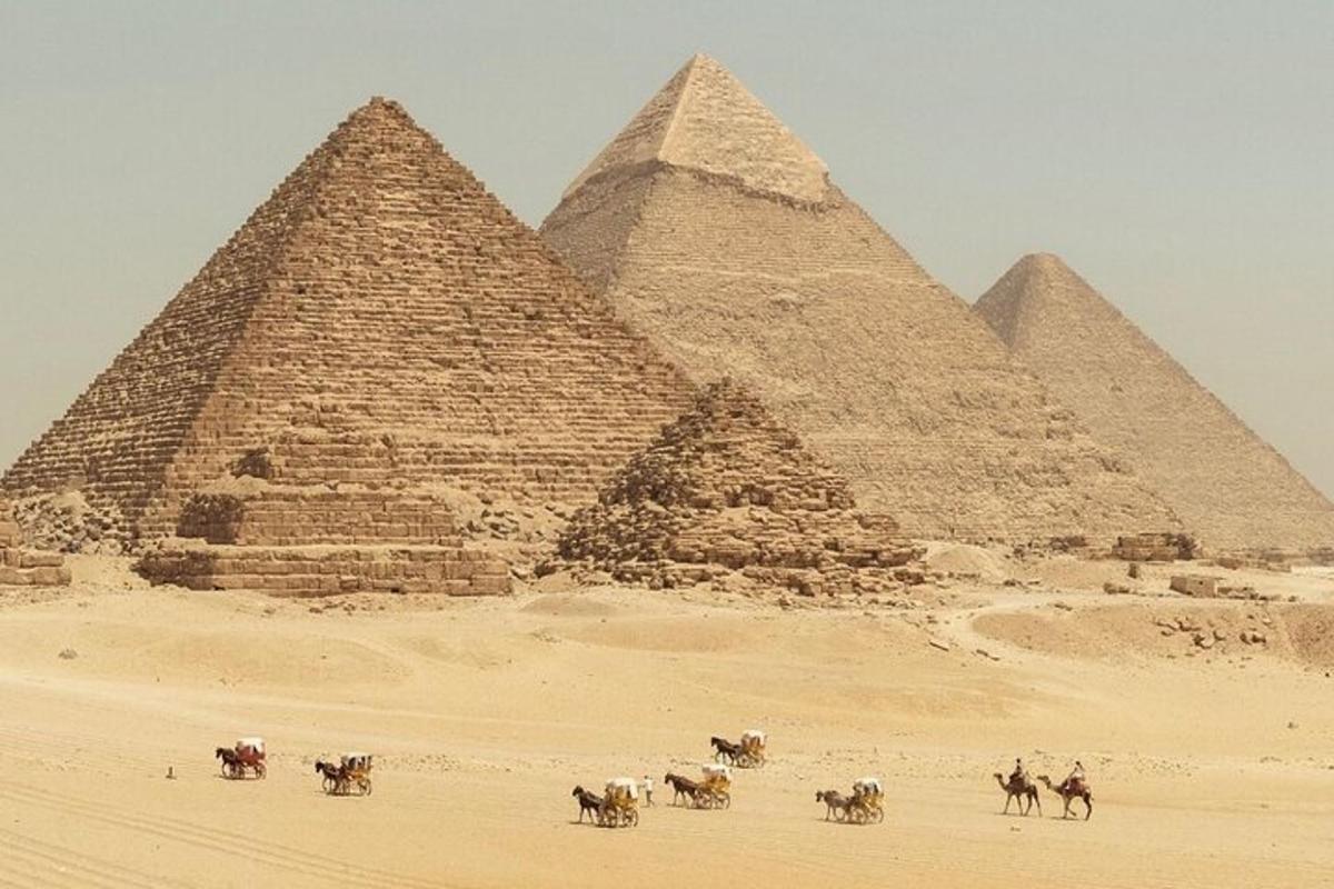 a group of people riding horses in front of pyramids