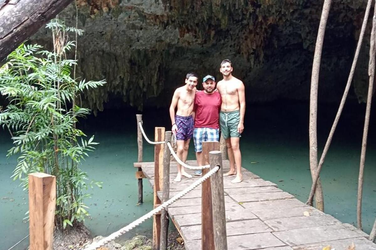 três homens em pé em uma ponte sobre um corpo d'água