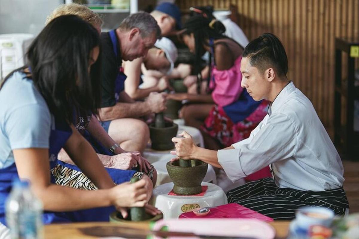 a group of people sitting around making pottery