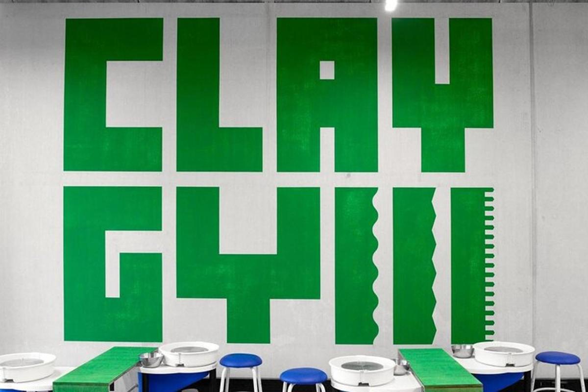 Una pared verde y blanca con algunas mesas y sillas.