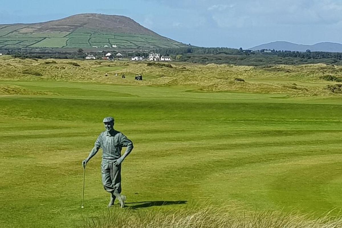moški, ki stoji na igrišču za golf in drži palico