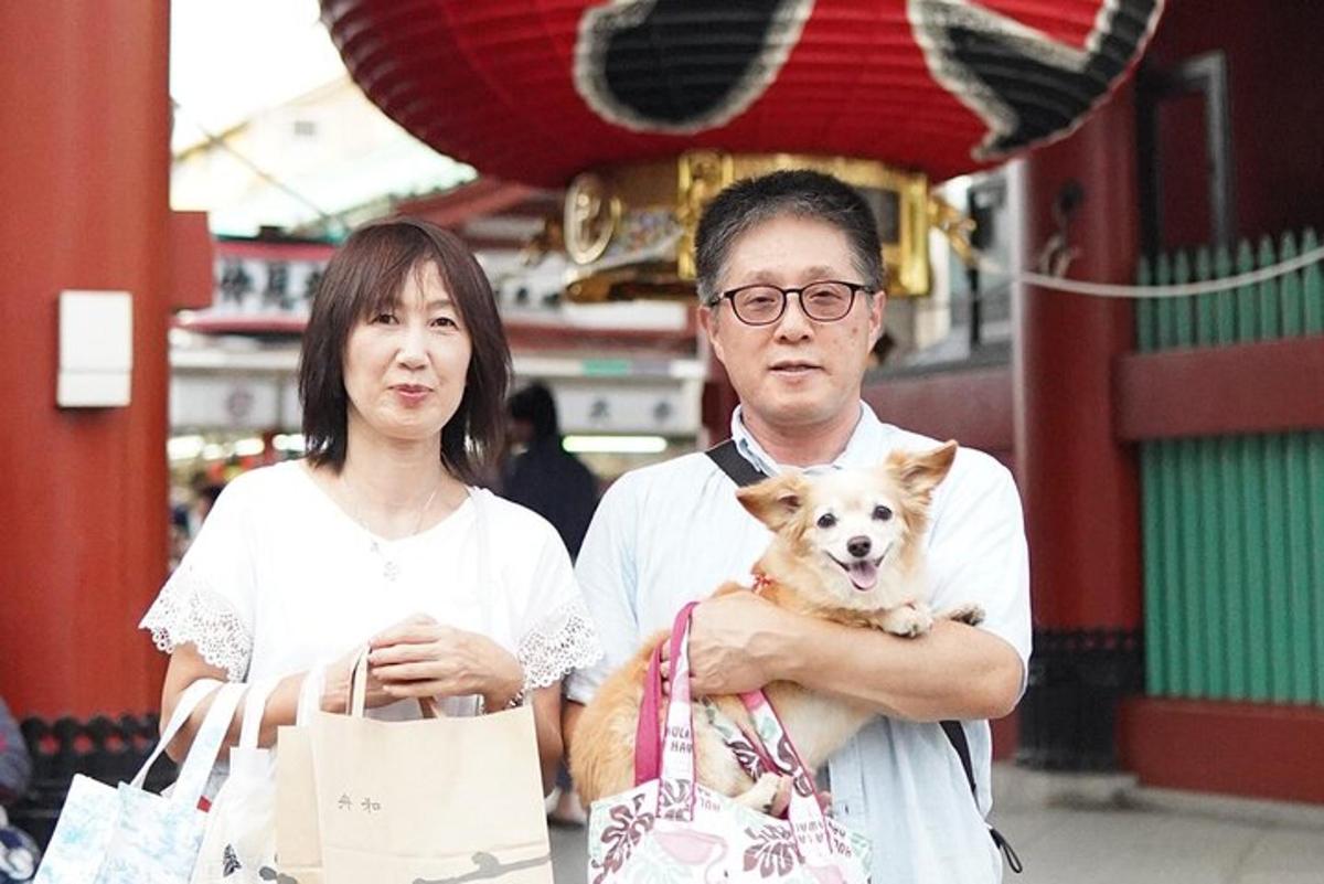 seorang lelaki dan seorang wanita memegang seekor anjing kecil