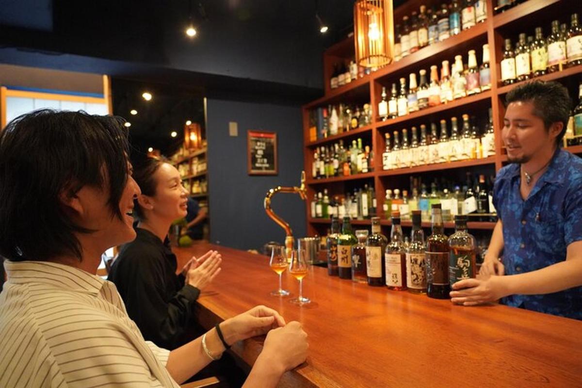 một nhóm người đang ngồi ở quầy bar với những chai rượu vang