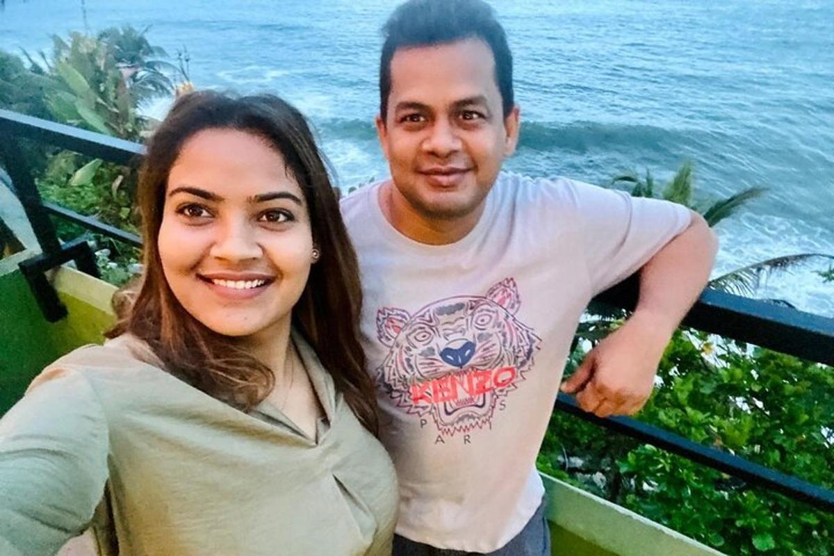 a man and a woman standing next to the water