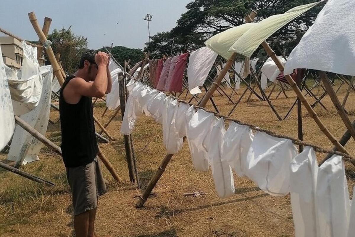 a man is standing next to a clothes line with clothes