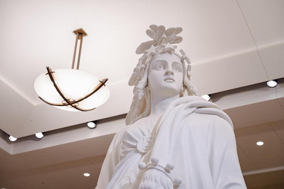 a statue in a building with aendant light