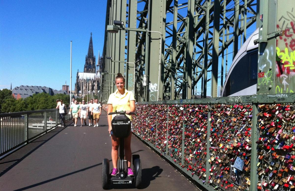 kona sem hjólar á Segway yfir brú