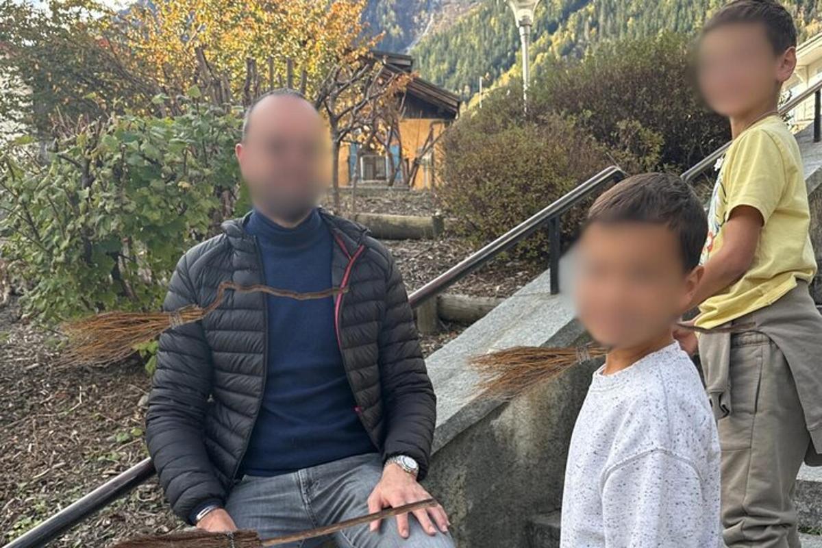 a man sitting on the stairs with two children