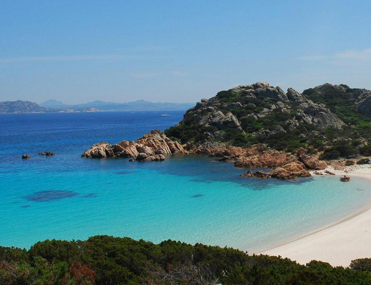 una spiaggia con un mucchio di rocce nell'acqua