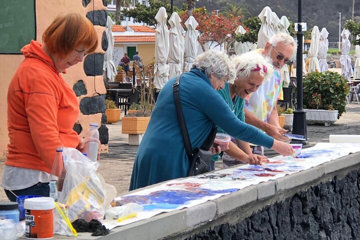 Un grupo de personas mirando arte sobre una mesa.