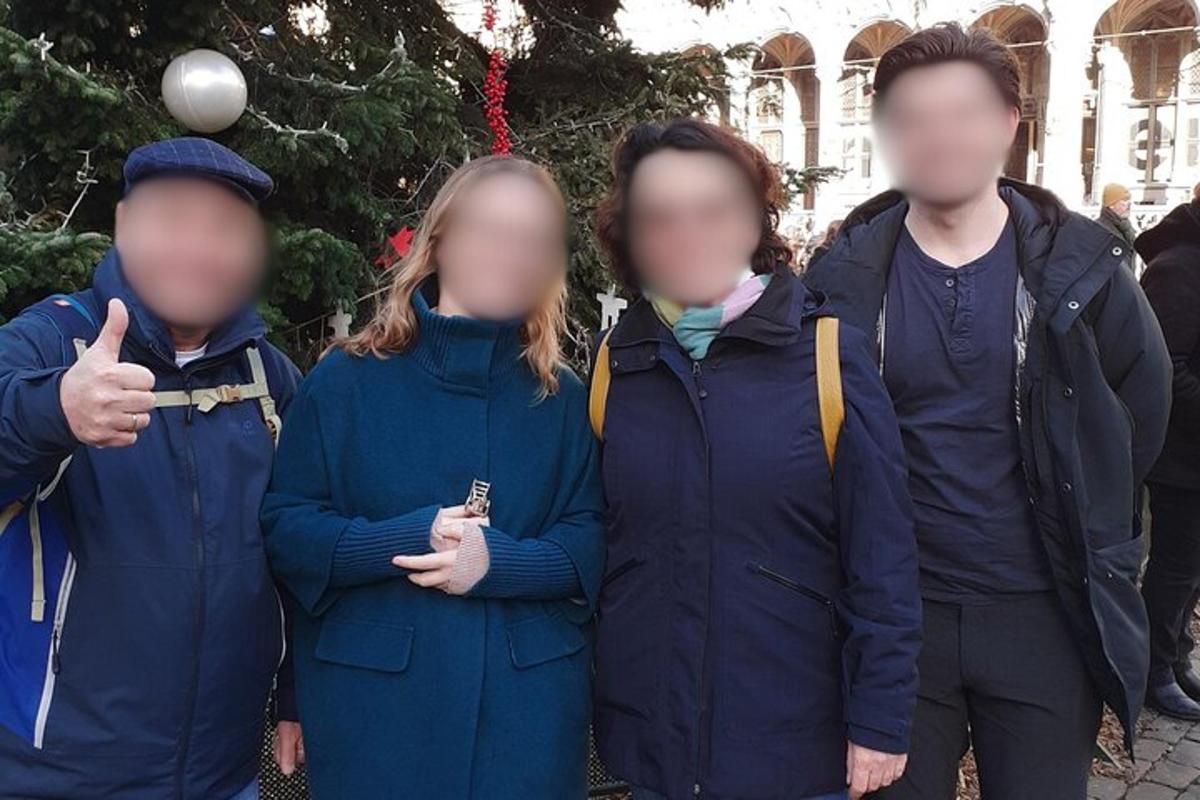 skupina lidí stojících před vánočním stromečkem