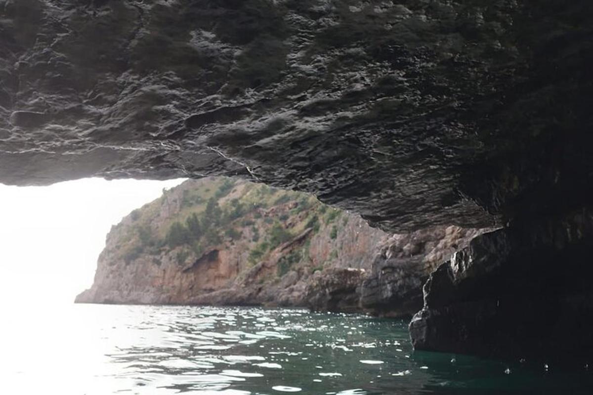 a cave in the side of a mountain in the water