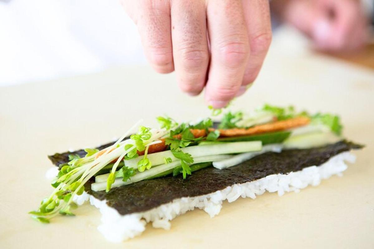 una persona che cosparge le verdure sopra un panino
