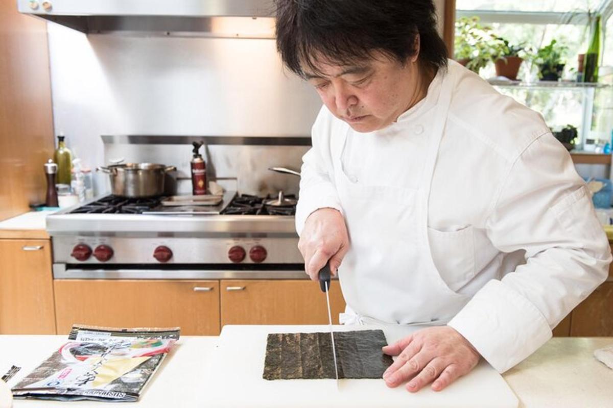 una donna in cucina che taglia un pezzo di legno
