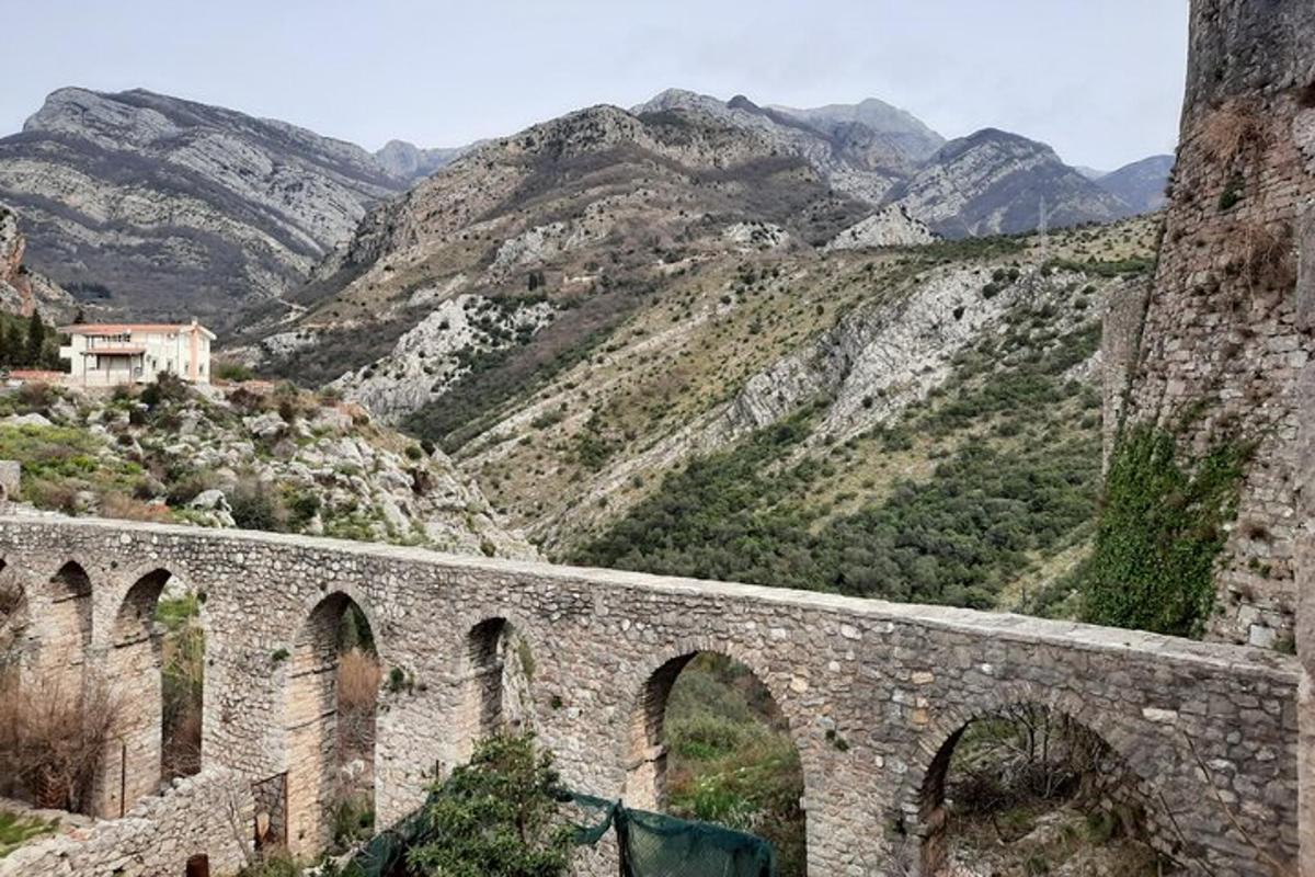 Un viejo puente de piedra con montañas al fondo
