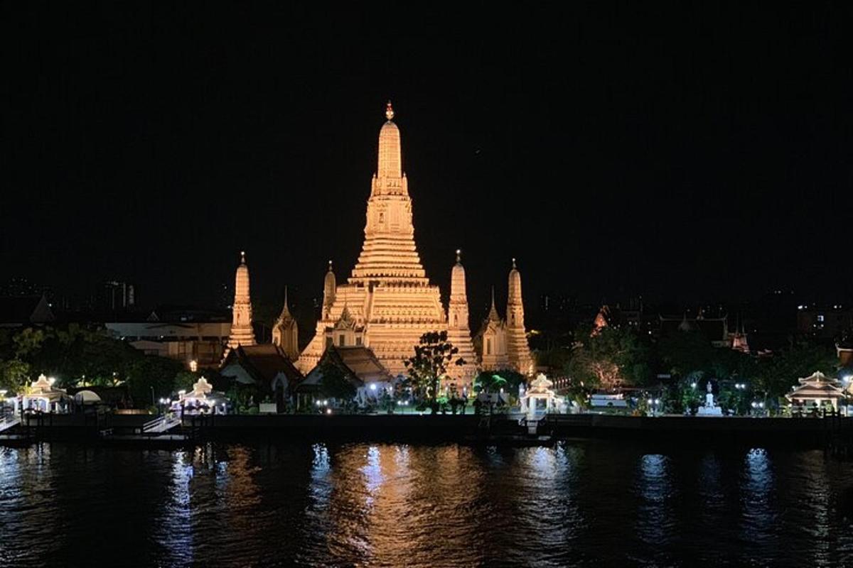 un grande edificio illuminato vicino all'acqua di notte
