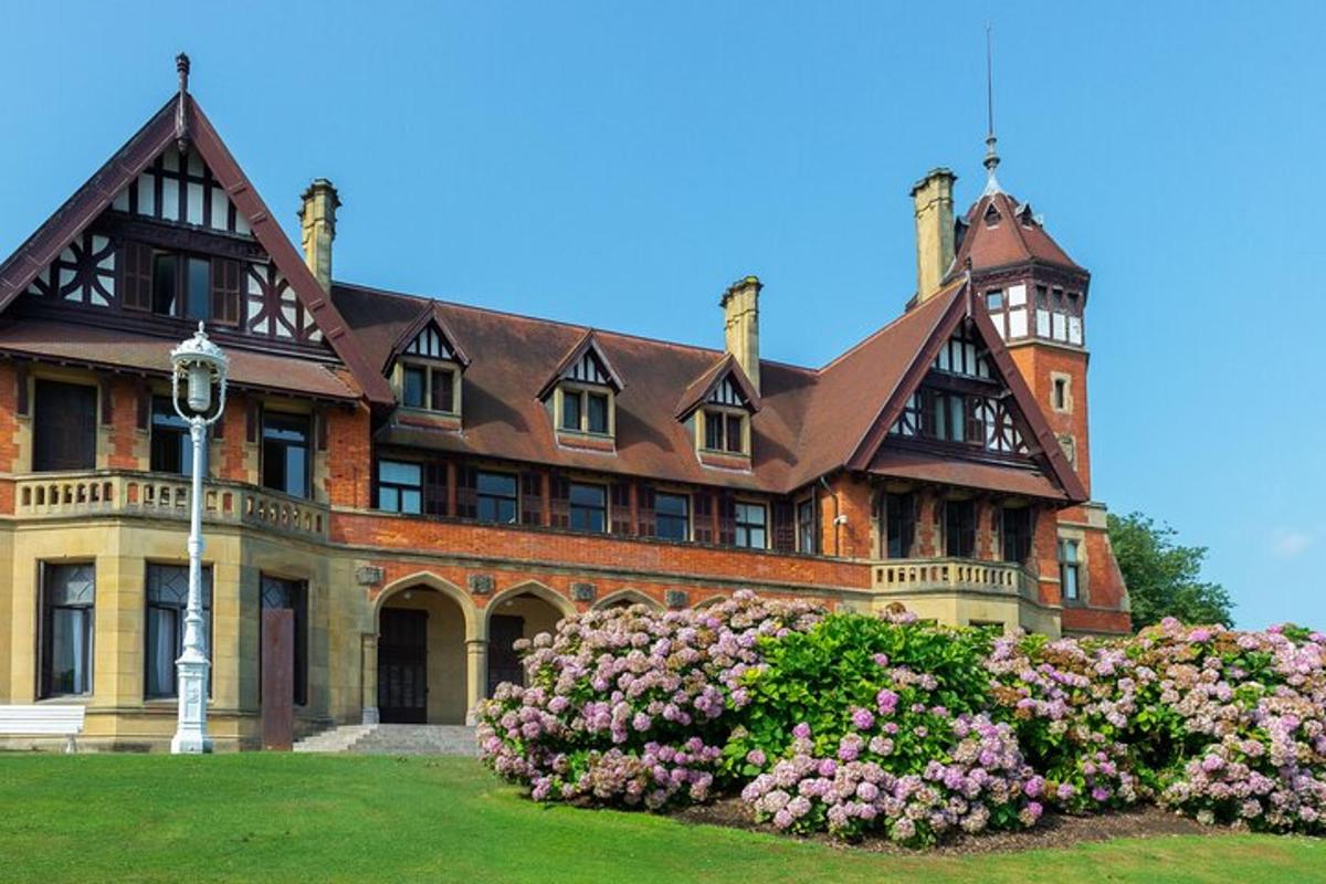 a large brick house with flowers in front of it