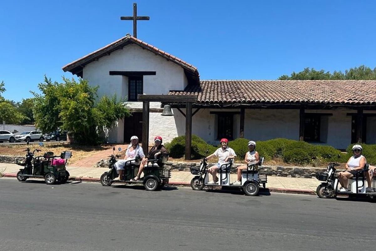 een groep mensen die op quads voor een kerk rijdt