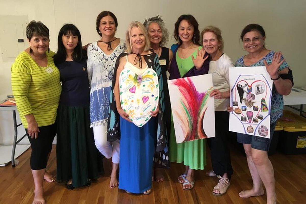 Un grupo de mujeres posando para una foto con sus obras de arte.