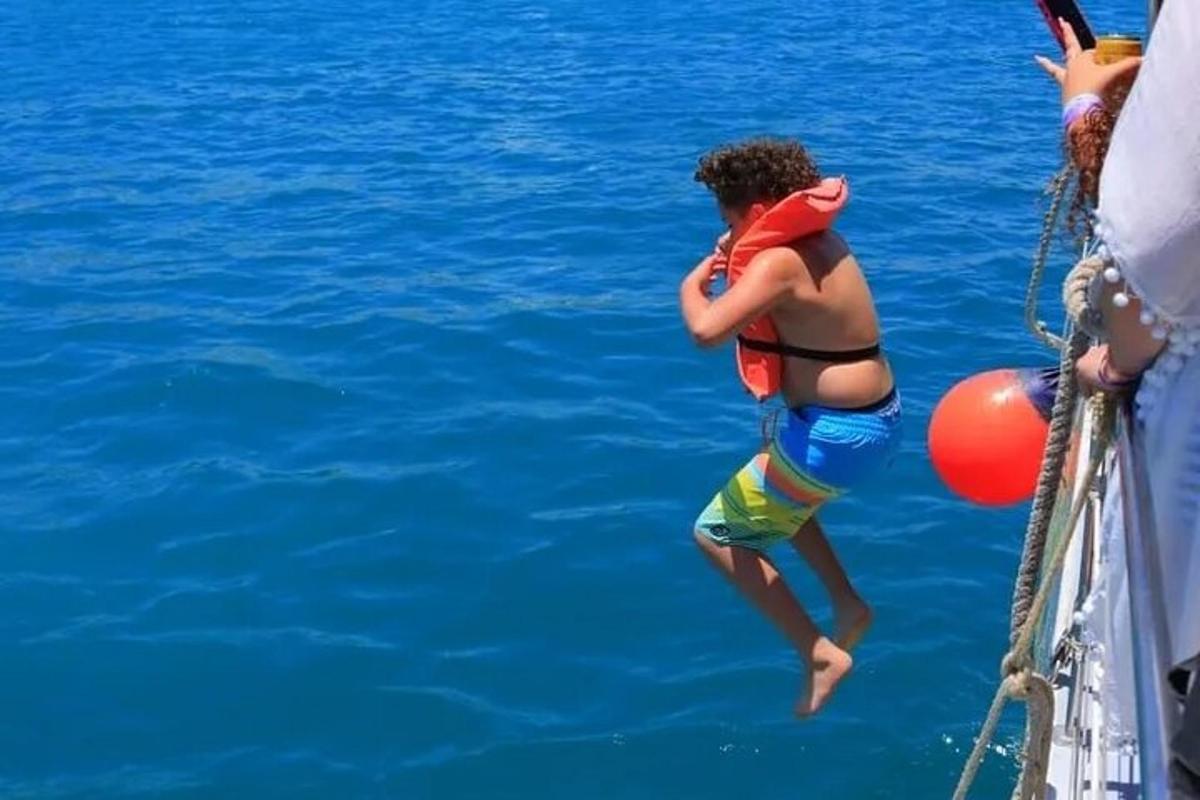 una donna che salta in acqua da una barca