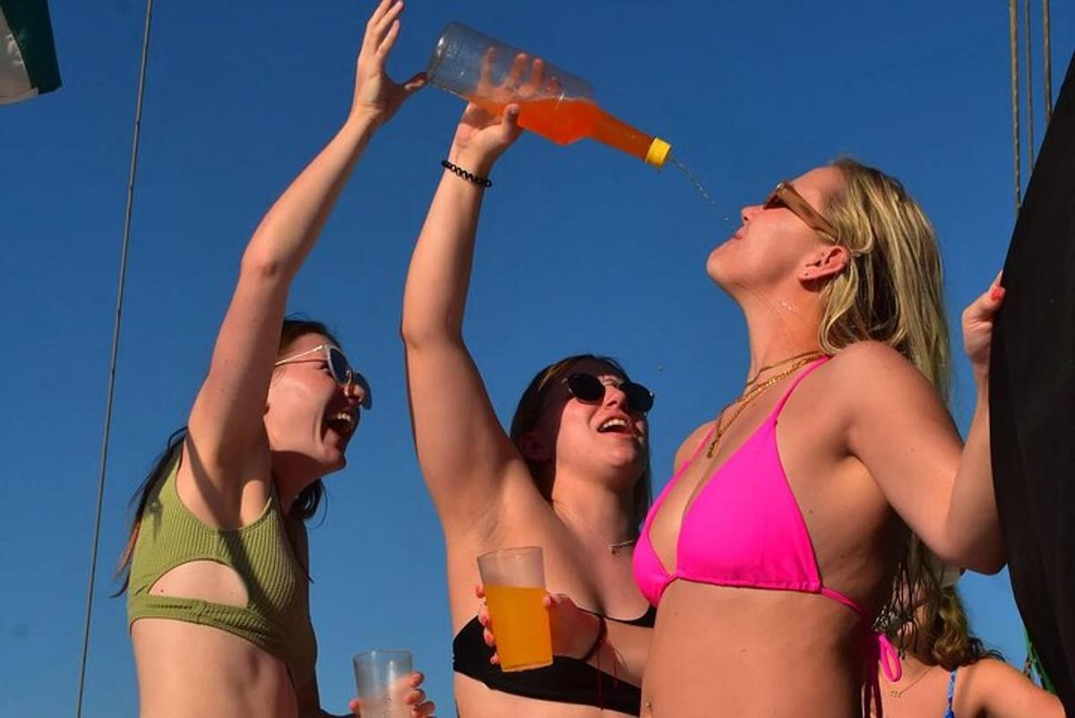 drie vrouwen in badpakken die water uit een fles drinken