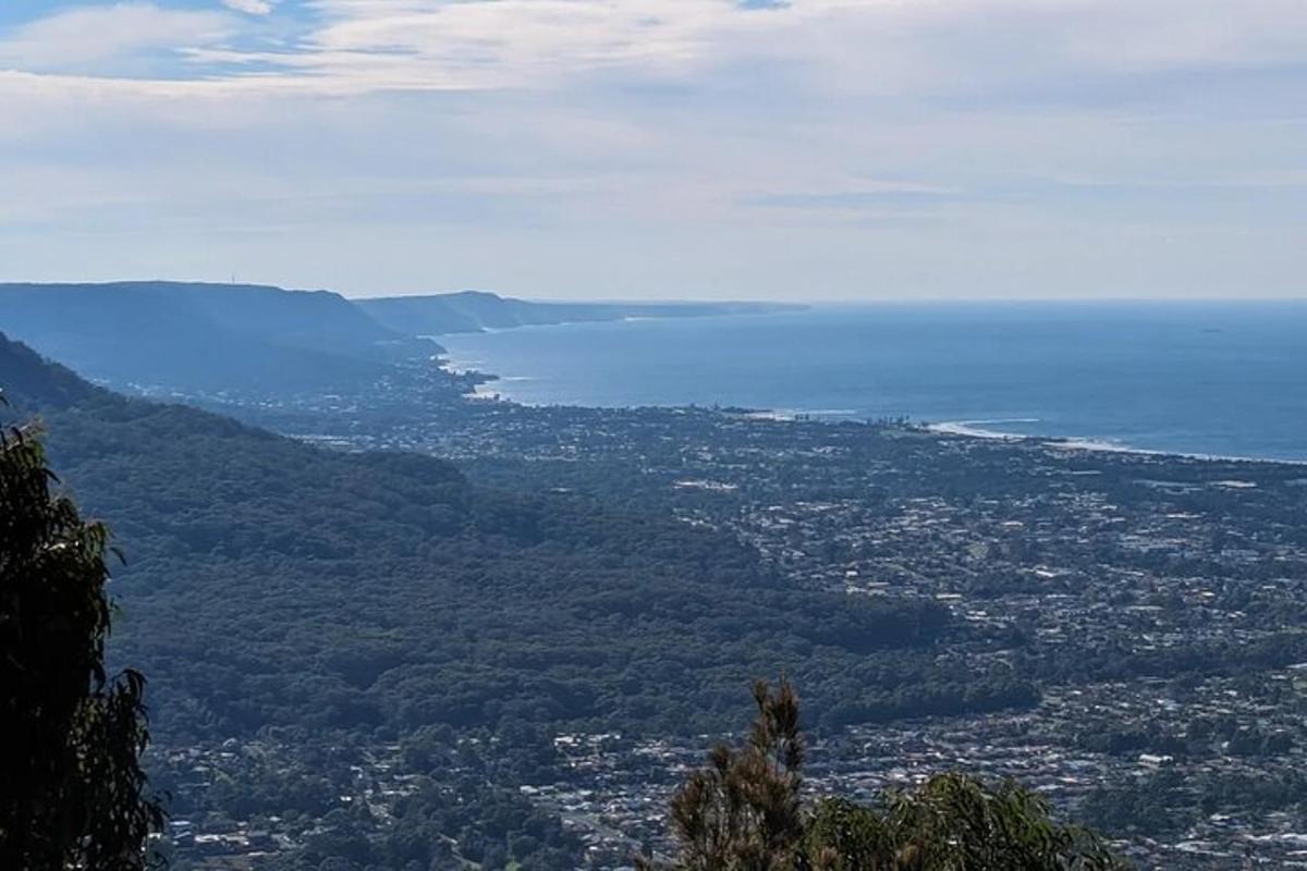 una vista di una città e dell'oceano da una montagna