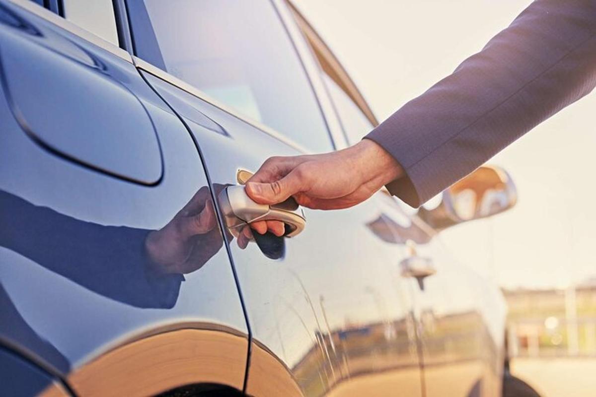 una persona tiene la maniglia della portiera di un'auto