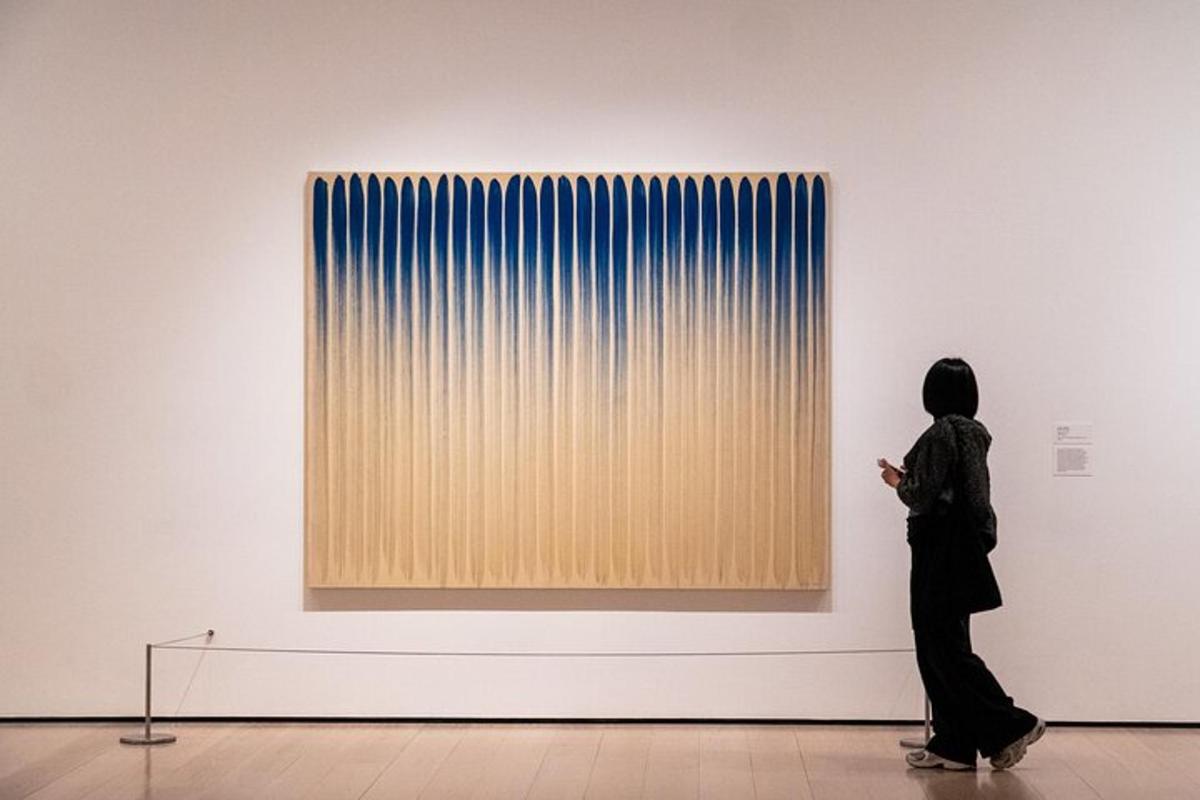 a woman looking at a painting in an art museum