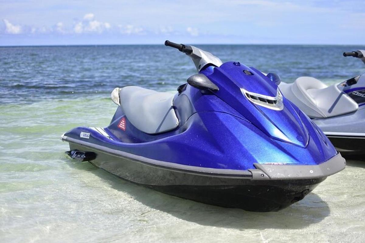 una moto d'acqua blu ferma sulla spiaggia vicino all'oceano