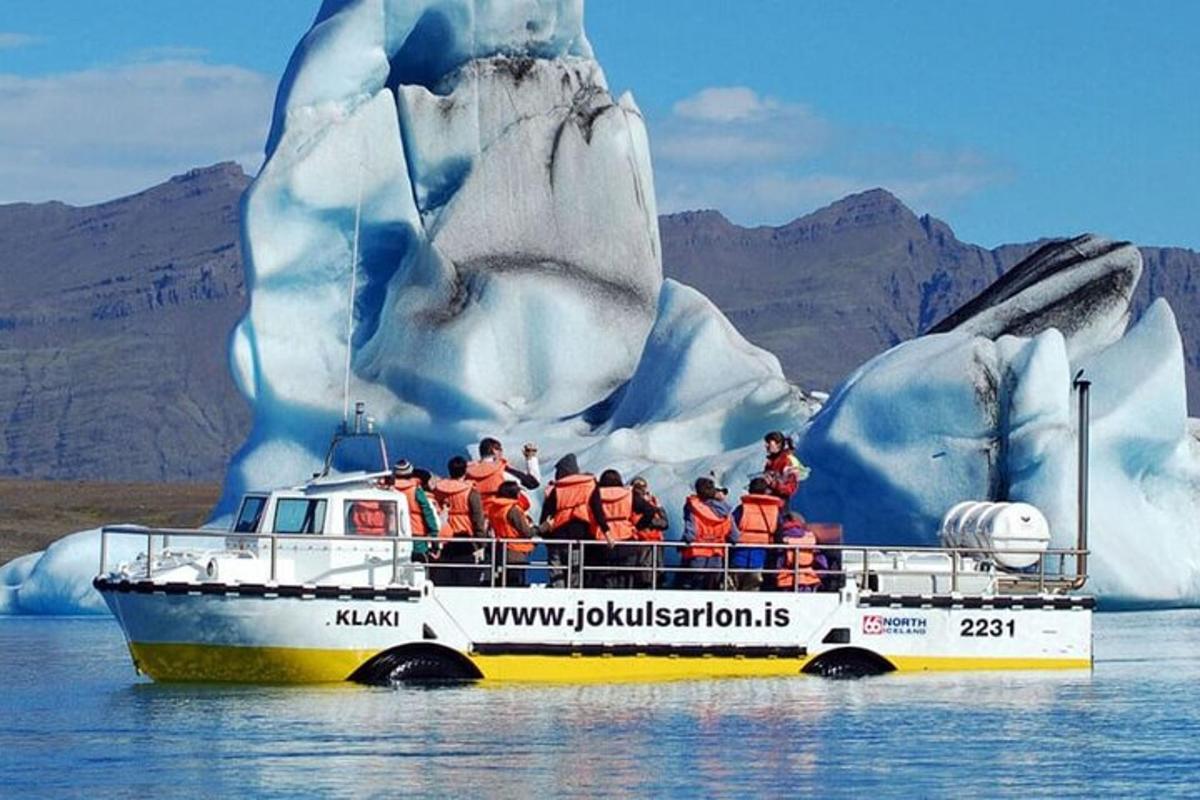 Un grupo de personas en un barco frente a un iceberg.