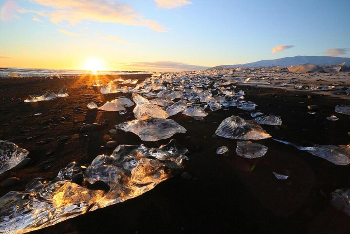 a group of rocks on a beach at sunset