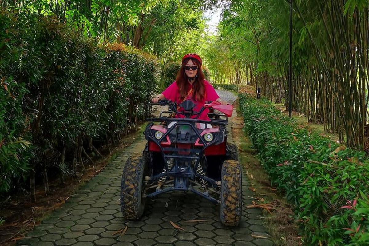 a woman riding a four wheeler on a path