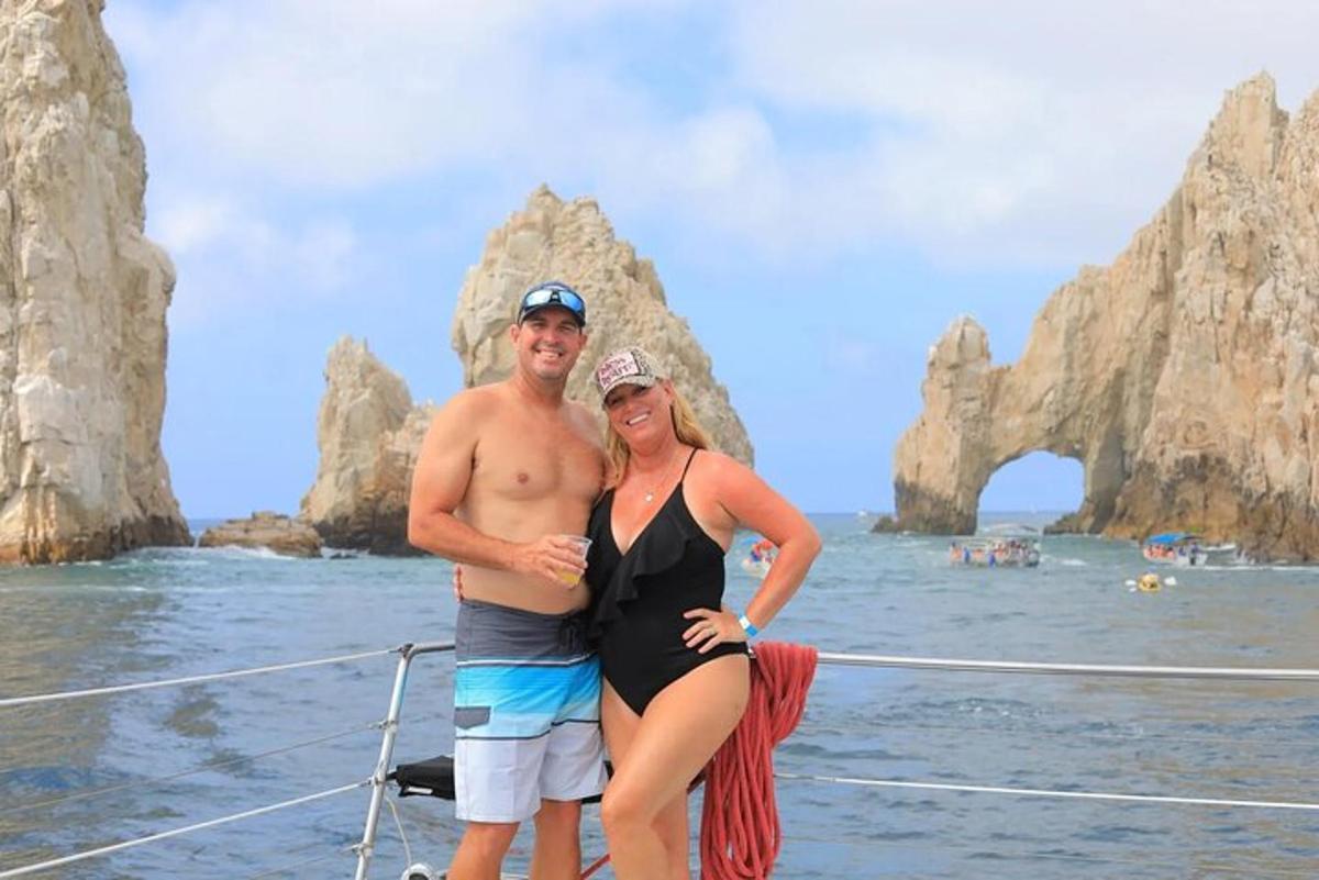 um homem e uma mulher em pé em um barco no oceano