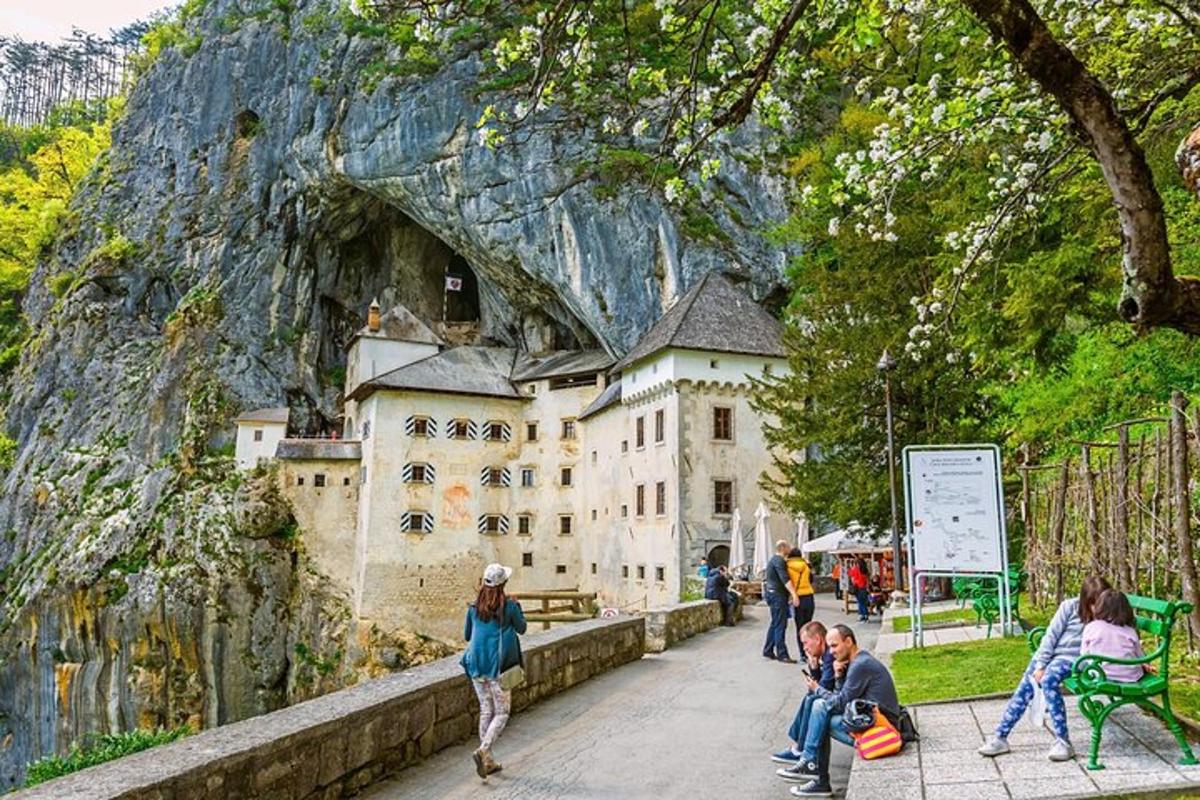 skupina lidí sedících na lavičce před hradem