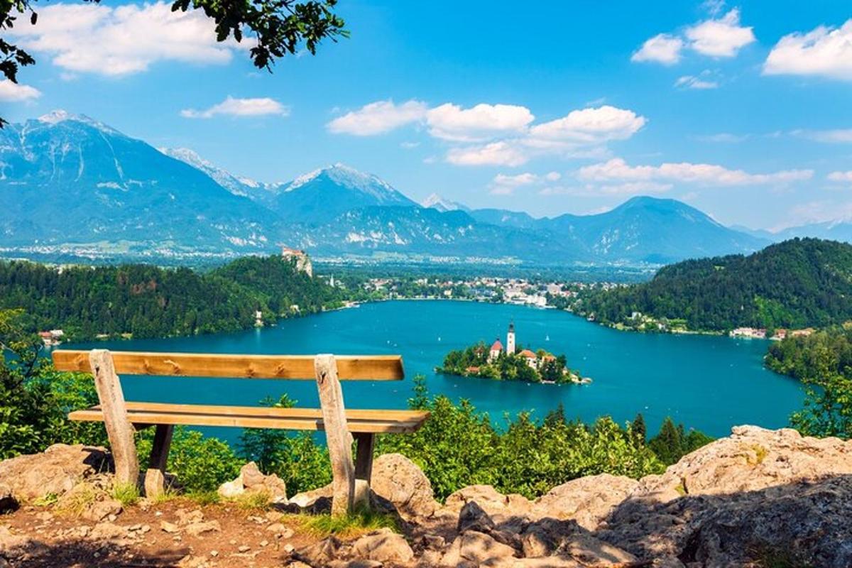 una panchina in cima a una collina che domina un lago