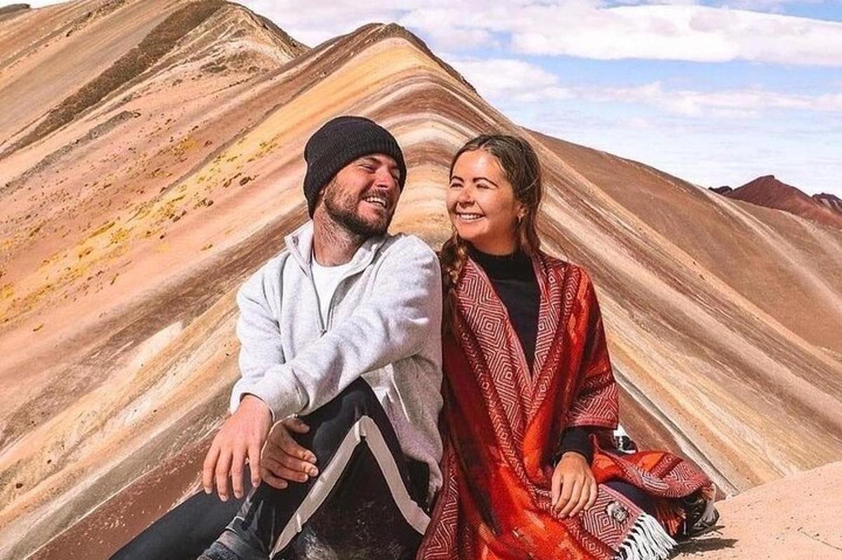 a man and a woman sitting in front of a mountain