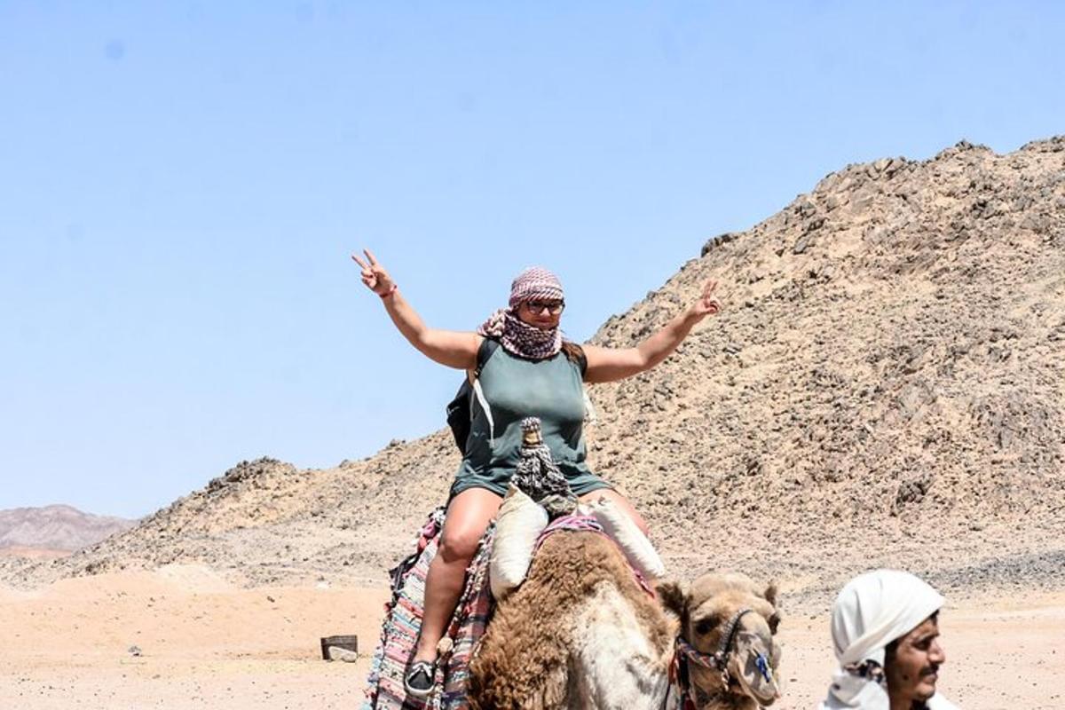 Una mujer montada en el lomo de un camello en el desierto