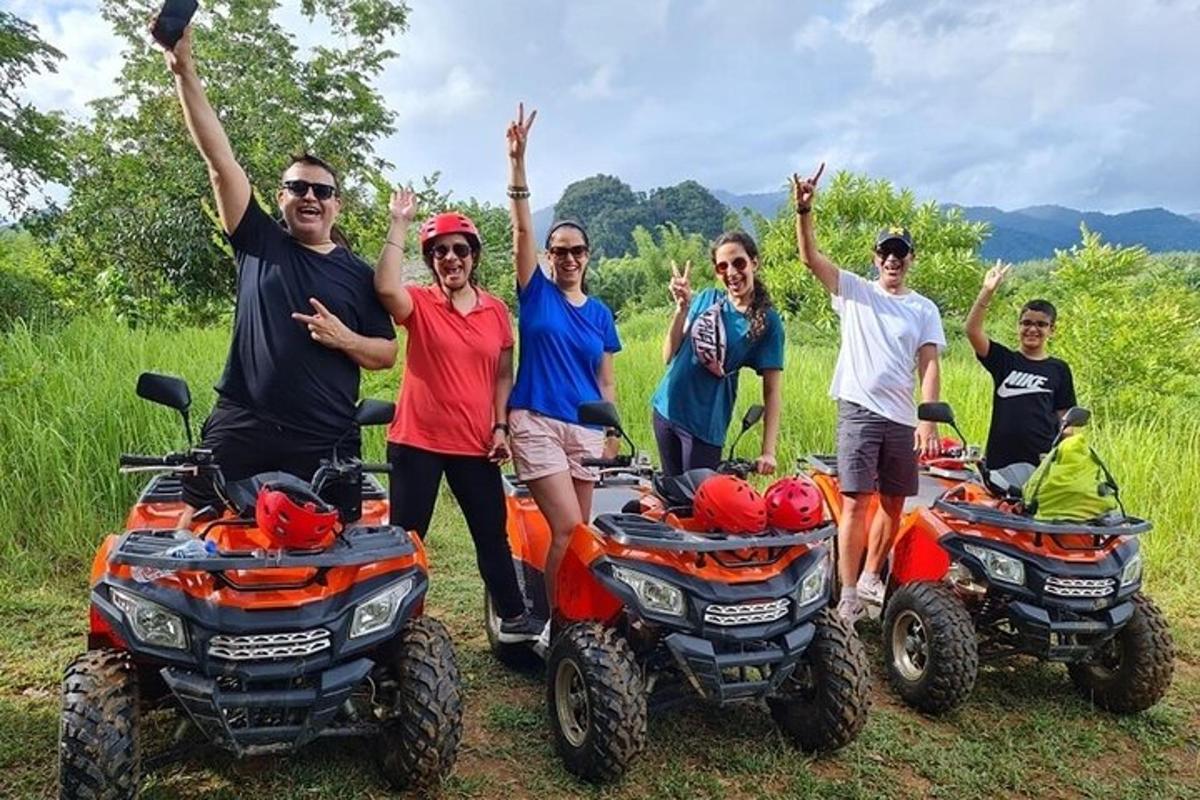 a group of people posing for a picture with atvs