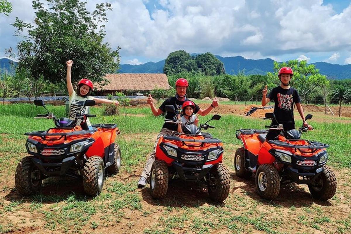 a group of four people riding atvs on a field