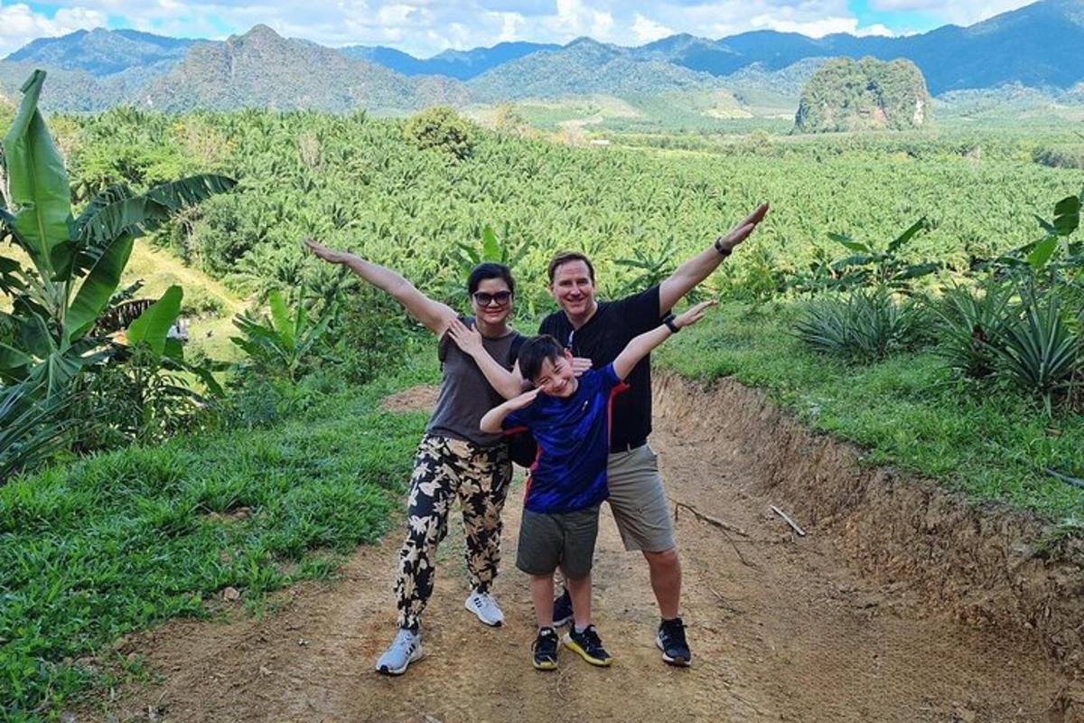 three people standing on a dirt road with their arms up
