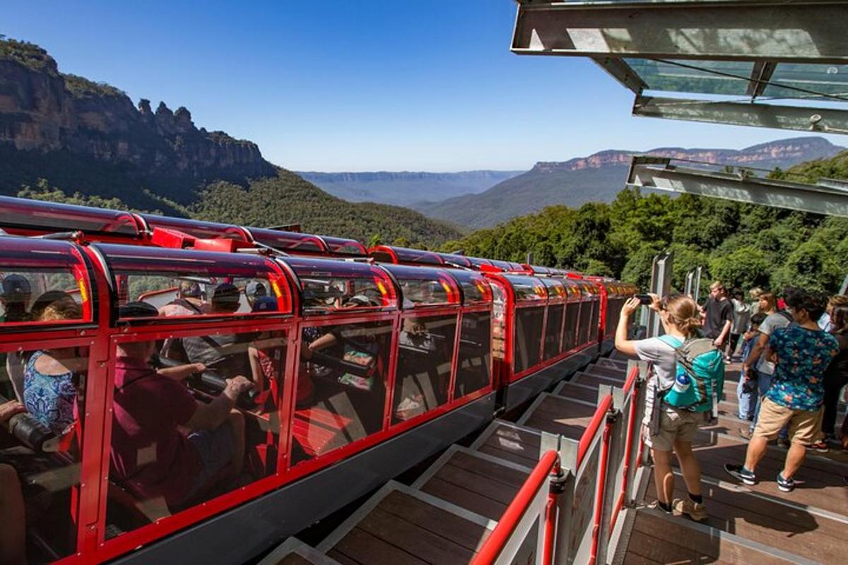 a group of people on a red train in the mountains