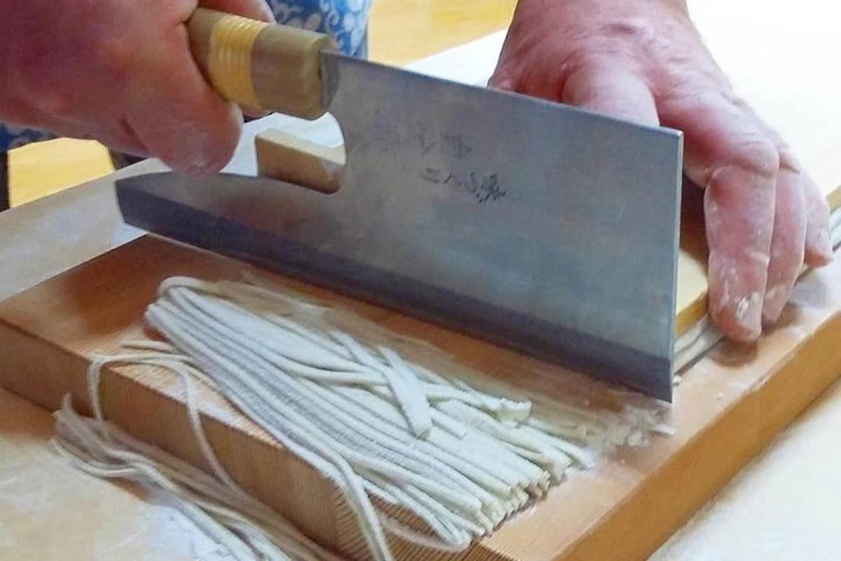 a person cutting a piece of cheese on a cutting board